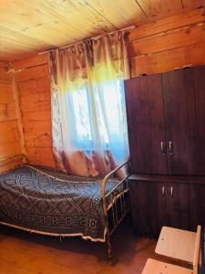 a bedroom with a bed and a window in a cabin at Chirukhi David Cottage in Shuakhevi