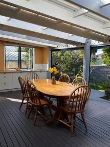 a wooden table and chairs on a deck at Clive Cottage in Clive