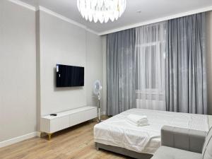 a bedroom with a bed and a tv on a wall at Buhar Zhyray Exclusive-1 in Zhezdi