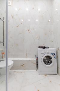 a white bathroom with a washing machine in it at Buhar Zhyray Exclusive-1 in Zhezdi +33 photos