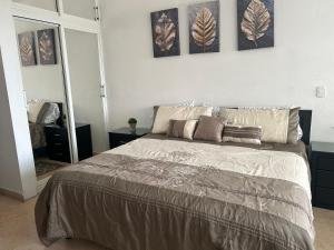 a bedroom with a bed with three pictures on the wall at 2 bdrm - Sleeps 8 -Ocean front -Ocean View in Mazatlán