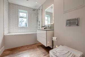a white bathroom with a tub and a sink at Fair Skies in St Merryn +44 photos
