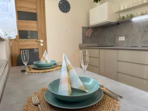 a kitchen with two plates and glasses on a table at Zeus apartmán in Rajecké Teplice +1 photo