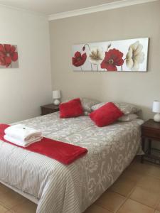 a bedroom with a bed with red pillows on it at The Nosh & Nod - Avon Terrace in York