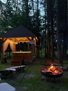 a fire pit in a field with a tent at Chatki Bernadki - Siedliska na Roztoczu in Siedliska +43 photos