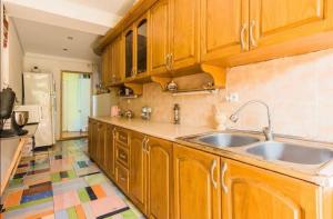 a kitchen with wooden cabinets and a sink at Yellow villa in Gonio in Gonio
