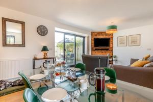 a living room with a glass table and chairs at Mavis Cottage - Swanmoor Grange in Chapelton