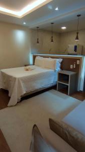 a bedroom with a large bed and a table at Pousada das Neves in Miguel Pereira
