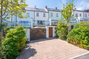 an exterior view of a house with a brick driveway at The Sandbox Apartment in Saundersfoot