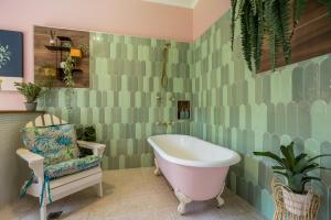 a bathroom with a bath tub and a chair at Babinda Quarters in Babinda +163 photos