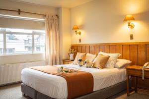 a bedroom with a large bed with a window at Hotel Museo El Greco Puerto Varas in Puerto Varas