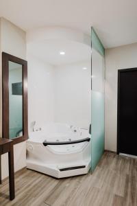 a bath tub in a bathroom with a mirror at Comfort Inn & Suites Tobago in Tobago Island