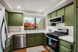 a kitchen with green cabinets and a window at Desert Blue River Retreat in Palm Springs