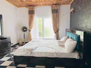 a bedroom with a large bed and a window at The Masken Murree in Murree