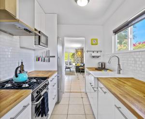 eine Küche mit weißen Schränken und einem Herd mit Backofen in der Unterkunft Cozy Desert Bungalow in Palm Springs