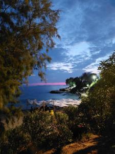 a beach with umbrellas and the ocean at night at S&M Cozy Garden Lagonisi in Lagonissi