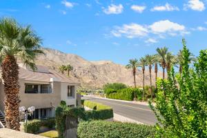 una casa su una strada con palme e una montagna di Sweet Citrus Condo a Palm Springs