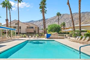una piscina con palme e montagne sullo sfondo di Sweet Citrus Condo a Palm Springs