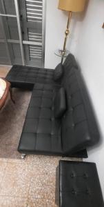 un divano in pelle nera in soggiorno con lampada di Apartamento BenRif a Santa Magdalena de Pulpis