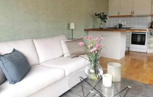 a white couch with a glass table with flowers on it at Seaside Guesthouse in Kalmar in Kalmar