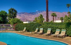 a group of chairs sitting next to a swimming pool at Cozy Ranch-Style Condo in Palm Springs