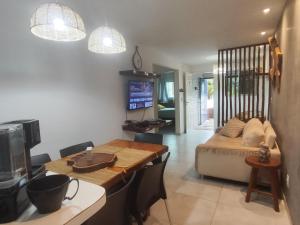 マラゴージにあるFlat Beira-Mar Maragogiのテーブルとソファのあるキッチンとダイニングルーム