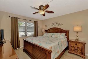 a bedroom with a bed and a ceiling fan at Carefree Coconut-2 bedroom condo with heated pool and close to beach in Siesta Key +79 photos