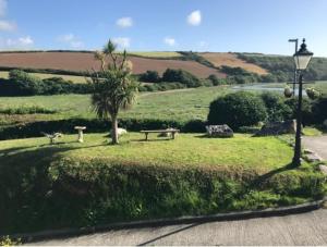 a park with a bench and a tree and a street light at Gannel View Apartment in Newquay