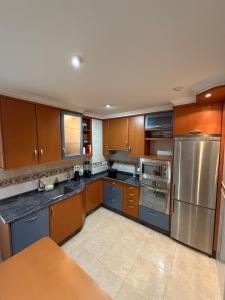 a kitchen with wooden cabinets and stainless steel appliances at Apartmento en Xove in Jove