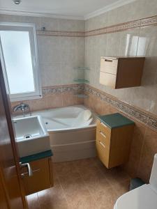 a bathroom with a bath tub and a sink at Apartmento en Xove in Jove +6 photos