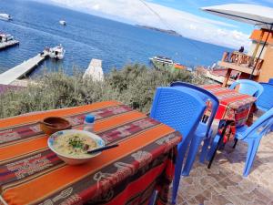 a table and chairs with a bowl of food on a table at Palacio del Inca Lodge Isla del Sol in Comunidad Yumani