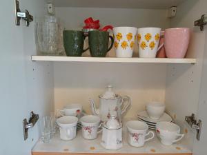 a shelf filled with cups and tea cups on it at Meadow View 10 in Krakow +18 photos