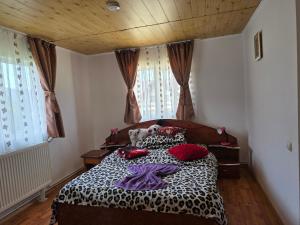 a bedroom with a bed with a teddy bear on it at Pensiunea Gaby in Dâmbovicioara