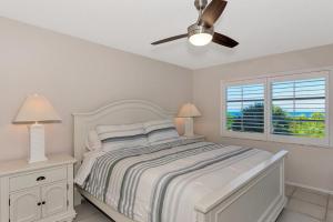 a white bedroom with a bed and a ceiling fan at Playing Hooky in Siesta Key +98 photos