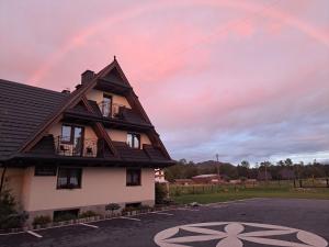 a rainbow in the sky above a house at Suchowianka Ski&Relax in Białka Tatrzańska