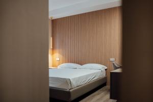 a bedroom with a bed with white sheets and pillows at Central Suites in Chieti