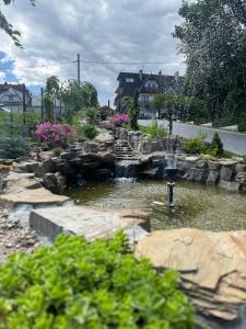 a pond with a fountain in a garden at Suchowianka Ski&Relax in Białka Tatrzańska