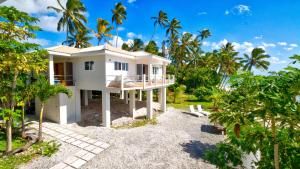 a house on the beach with palm trees at Ocean Spray Villas in Rarotonga