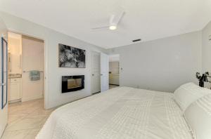 a white bedroom with a large bed and a tv at Calm Seas in Englewood +42 photos