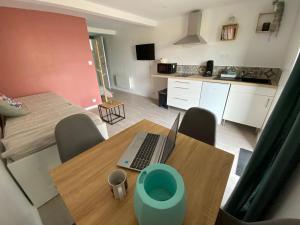 a room with a table with a laptop on it at Studio de la Baroud Family in La Pommeraye