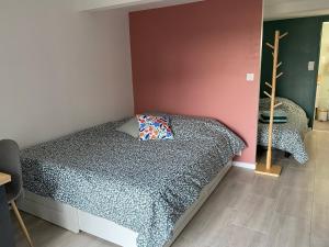 Un dormitorio con una cama con una almohada encima. en Studio de la Baroud Family, en La Pommeraye