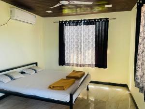 ein Bett in einem Zimmer mit Fenster in der Unterkunft Bs patil farmhouse by Prashant Patil in Karjat