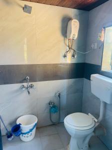 ein Bad mit WC und ein Telefon an der Wand in der Unterkunft Bs patil farmhouse by Prashant Patil in Karjat