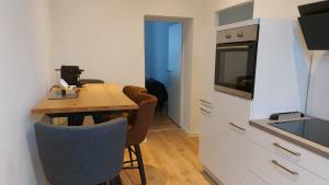 a small kitchen with a wooden table and chairs at City Appartement in Mönchengladbach +1 photo