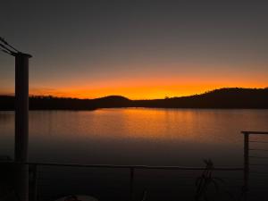 ein Sonnenuntergang über einem großen Gewässer in der Unterkunft Bunyip Burrows in Lake Bennett