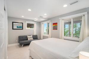 een slaapkamer met een bed, een bank en ramen bij Private Beachfront Lake Michigan Getaway in West Olive
