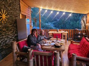 two people sitting at a table in a room at Dadu Guest house in Davberi