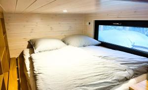 a bed in a small room with a window at Tiny House am Ranziger See in Tauche