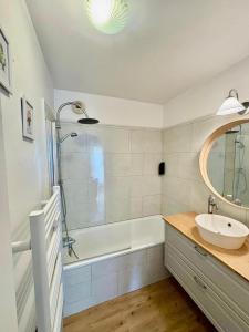 a bathroom with a tub and a sink and a shower at Appartement idéal famille - Disneyland à 5 min in Montévrain