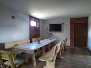 a dining room with a table and chairs and a television at Domek pod Koroną Bieszczad in Strzebowiska